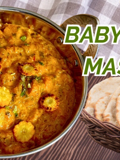 A creamy and flavorful plate of Restaurant-Style Baby Corn Gravy, garnished with fresh cilantro, served with naan and rice.
