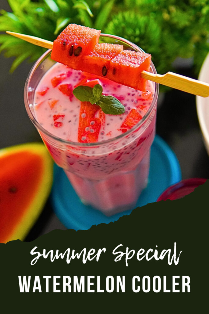 A refreshing Watermelon Rose Milk Sharbat served in a glass, with watermelon cubes, soaked sabja seeds, and rose syrup mixed together, garnished with fresh basil leaves and rose petals for a cool summer drink.