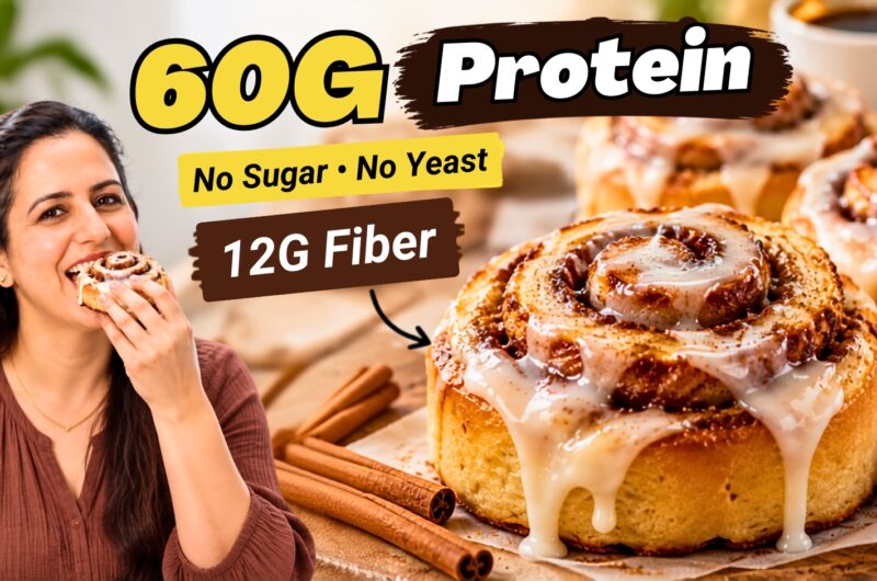 Pumpkin cinnamon rolls with cream cheese glaze dripping down the sides, cinnamon sticks beside them