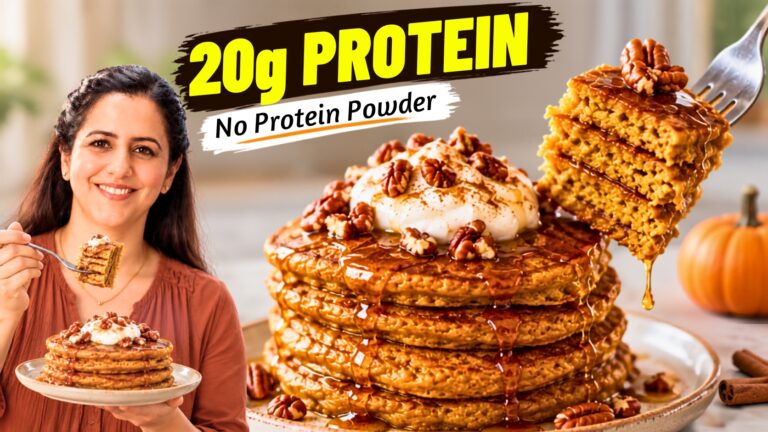 Stack of fluffy pumpkin protein pancakes topped with Greek yogurt and pecans, drizzled with maple syrup