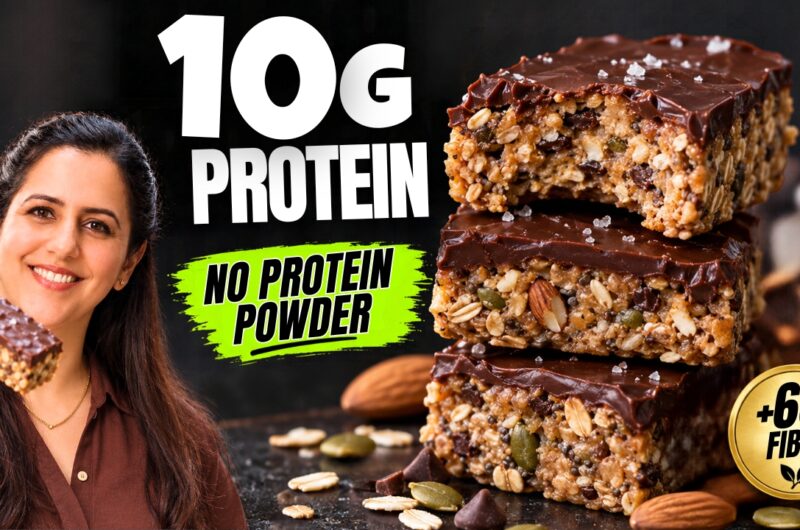 Stack of no-bake protein bars topped with dark chocolate showing oats, chia, and seeds inside