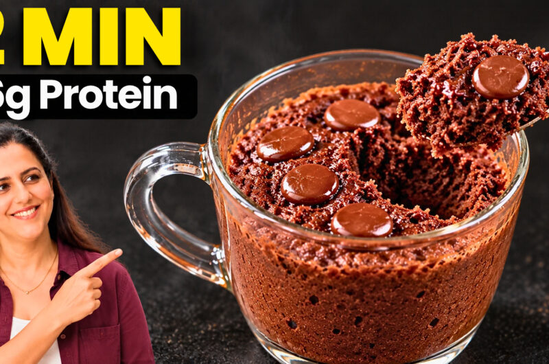 Spoon lifting a fudgy chocolate protein mug cake with a melted chocolate center from a white mug