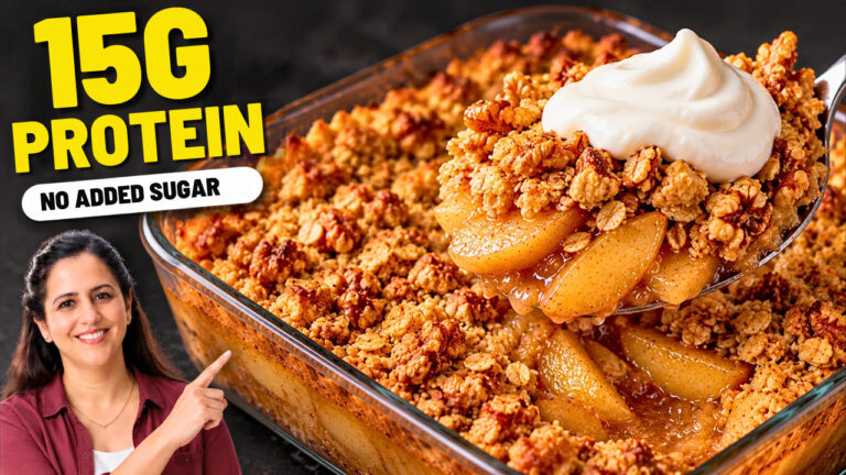 Bowl of healthy apple crisp with a crunchy oat and walnut topping and a spoonful of Greek yogurt cream