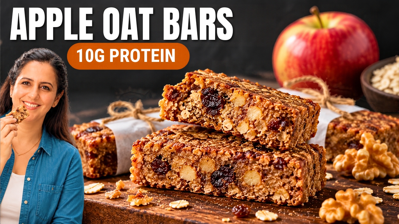 Stack of high protein apple oatmeal bars with walnuts and raisins on a wooden board, with a red apple behind