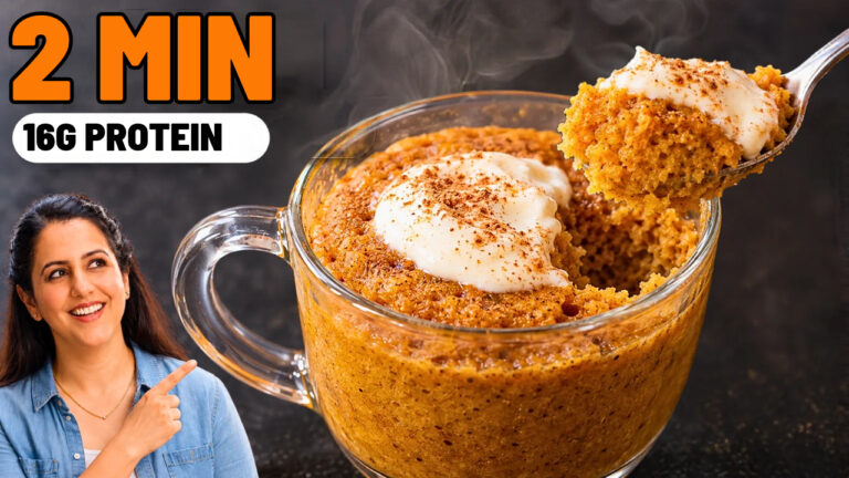 Pumpkin mug cake in a glass mug topped with Greek yogurt and pumpkin spice, with a spoonful lifted out