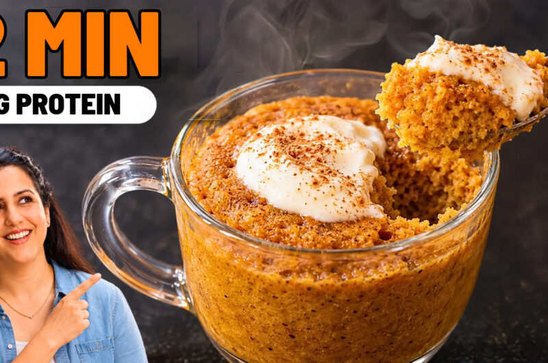 Pumpkin mug cake in a glass mug topped with Greek yogurt and pumpkin spice, with a spoonful lifted out