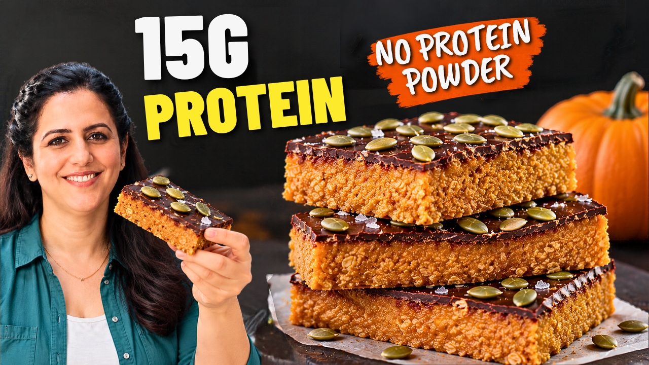 Stack of three no-bake pumpkin protein bars with a dark chocolate top and pumpkin seeds •